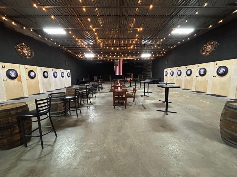 The private south-side venue: dartboards numbered along both walls, whiskey barrels for tables and string lights overhead.
