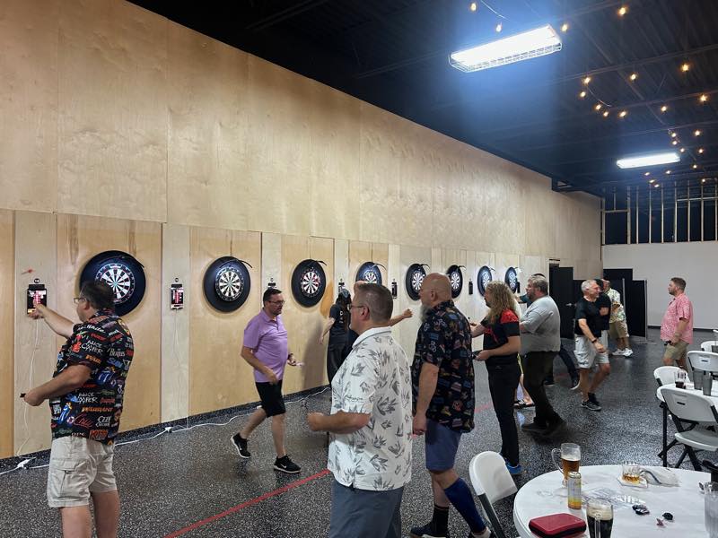 Players throwing at boards 18 through 21, each with a DartConnect scoreboard mounted beside it.