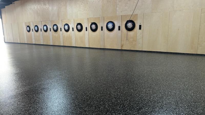 A low view down the board wall across the speckled epoxy floor.